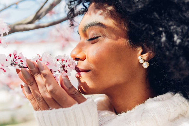 African-woman-smelling-pink-flowers